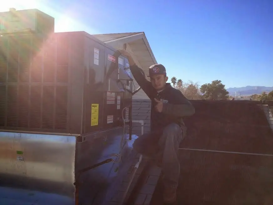 HVAC technician performing Boiler Repair on a rooftop unit in Maysville
